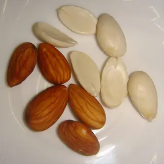 almonds portion size: whole and halved almonds arranged on white plate