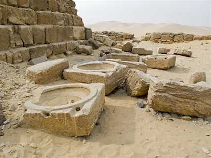 ancient egyptian sun temple ruins with large stone basins in desert landscape near giza pyramids