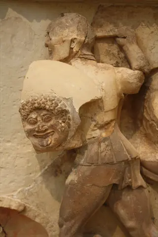 ancient greek stone relief depicting a warrior with gorgon-head shield, classical greece period