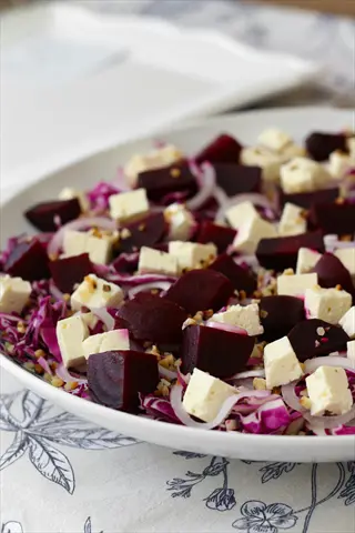 beet and feta salad bowl with red cabbage, pickled onions, toasted nuts, and ingredients for beet feta dip