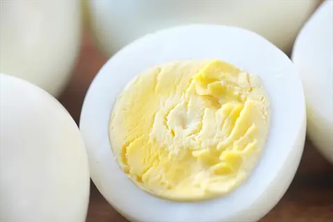 boiled eggs nutrition: close-up of halved hard-boiled eggs showing white shells and yellow yolks, highlighting choline-rich nutrition