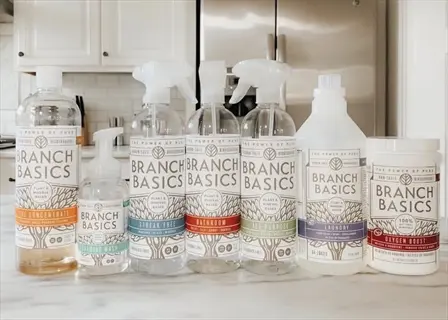 branch basics natural kitchen cleaner and cleaning product bottles (concentrate, foaming wash, all-purpose, bathroom, laundry, oxygen boost) on kitchen counter