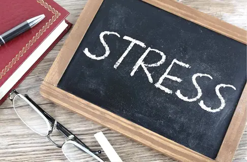 chalkboard displaying 'stress' with study materials, symbolizing exam anxiety relief strategies for phase 4: stress reduction