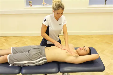 chest massage: female therapist performing chest massage on a male client in a clinical setting with anatomical models