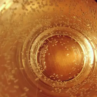 close-up of bedside water glass with carbonated water bubbles, illustrating hydration management