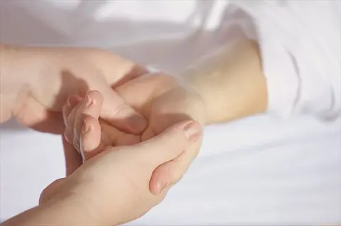 close-up of hands self massage: two hands gently massaging another hand in a therapeutic setting, illustrating self-care technique
