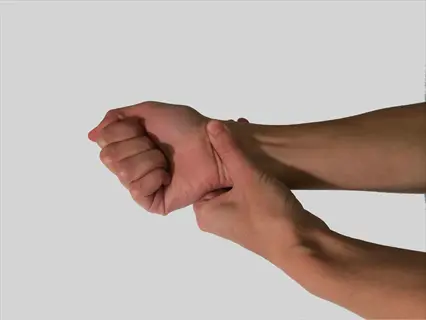 close-up of one hand touching the wrist point on another hand (clenched fist position) against a plain white background