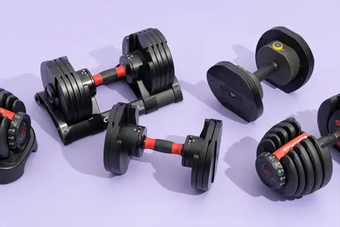 collection of adjustable dumbbells set on purple background