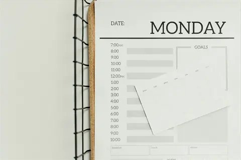 custom daily planner for monday with hourly time slots, goals section, and weekly calendar on wire rack