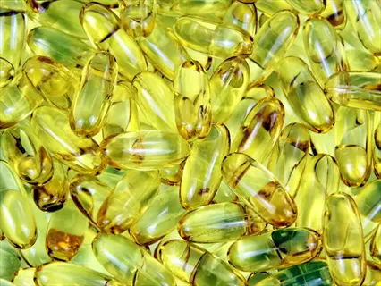 dense cluster of translucent golden fish oil capsules, primary dietary source of eicosapentaenoic acid (epa). these omega-3 supplement softgels are shown en masse