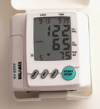 digital blood pressure monitor (balance kh 8099) showing systolic 122, diastolic 65, and pulse 75 readings on its display