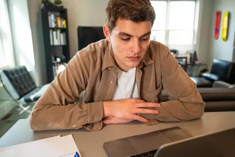 focused person working on a laptop in a home office environment, exemplifying focus enhancement during remote work