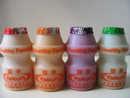 four yakult probiotic yogurt drinks in colorful bottles, showcasing yogurt probiotic cultures for gut health