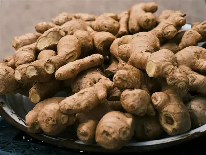 fresh ginger root with rough, textured skin piled on a plate