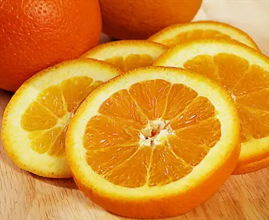 fresh oranges fruit: whole oranges and vibrant orange slices with visible segments on a wooden cutting board