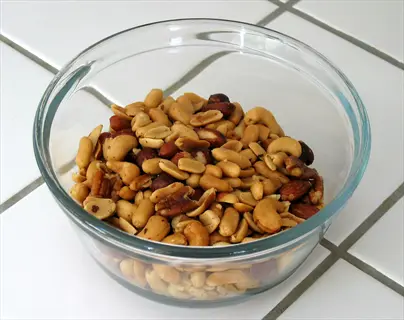 glass mixed nuts bowl with assorted nuts on tiled counter, a snack solutions option
