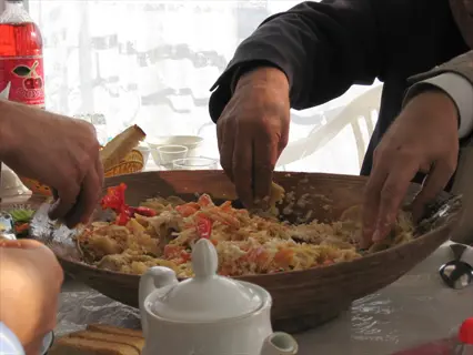 grateful hands food: multiple hands sharing a large bowl of food in a communal setting, expressing gratitude through shared nourishment