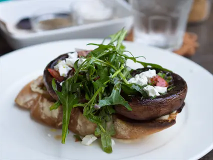 grilled feta vegetables open-faced sandwich with portobello mushrooms, arugula, and crumbled feta on toasted bread