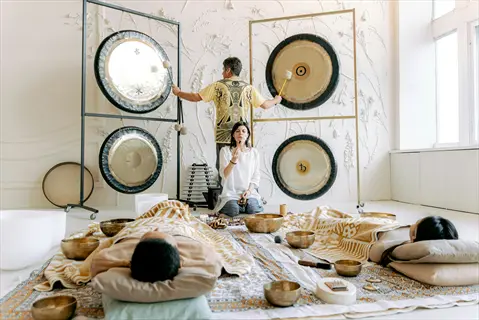 group meditation sound bath with gongs, sound bowls, and instruments for consciousness expansion in a therapeutic setting