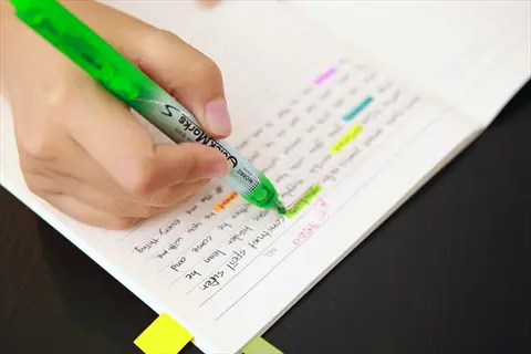 hand highlighting handwritten text in notebook with green marker, demonstrating learning retention notes for phase 3: knowledge integration