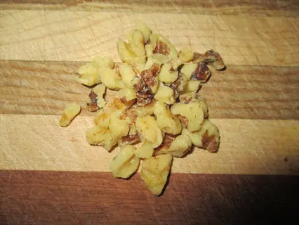 handful of walnut pieces scattered on a striped wooden cutting board