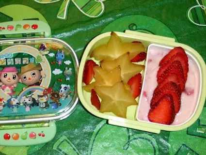 healthy bedtime snack in animal crossing bento box: starfruit stars, sliced strawberries with yogurt for bedtime nutrition