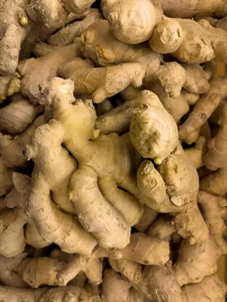 heap of fresh ginger roots with rough, knobby texture