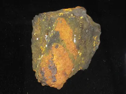 iron oxide mineral specimen: rust-colored crystalline structure with metallic flecks on dark velvety background