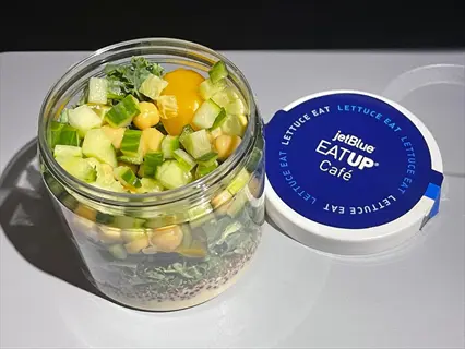 jetblue eatup café quinoa salad cup with chickpeas, cucumber, cherry tomatoes, and greens in clear container