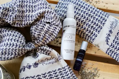 lavender company drawer sachet herbs with aromatherapy spray and roller bottle on rustic wooden surface