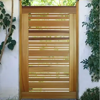 modern wooden outer gate with horizontal slats in a white stucco wall, surrounded by lush green plants