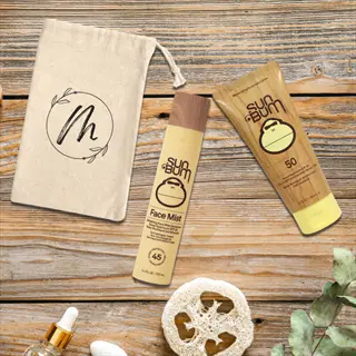 natural sun protection flat lay: sun bum spf 50 sunscreen, spf 45 face mist, monogrammed pouch, loofah, and aloe plant on rustic wood