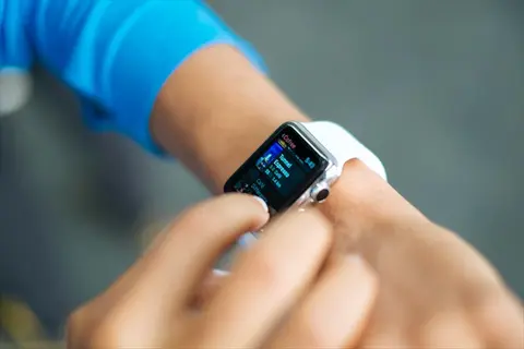 person in blue sleeve interacting with a smartwatch, showcasing wearable health tracking technology