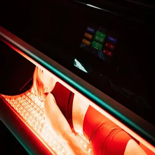 person using home light therapy device with red led panels and digital timer display showing 01:55
