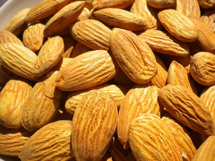 pile of raw almonds with natural brown skin, unshelled and whole