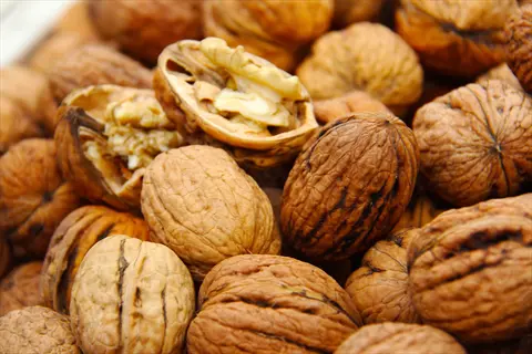 pile of walnuts (whole and cracked open) showing nuts and seeds - embodies 'nuts & seeds'
