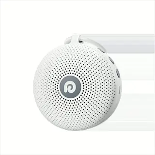 portable noise machine: compact round white device with carrying loop, speaker grille, and control buttons. palm-sized for travel sleep environments