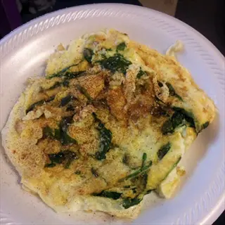 post workout meal: spinach and cheese omelet on a white plate. illustrates meal timing strategies for optimal muscle recovery with protein and nutrient-dense ingredients