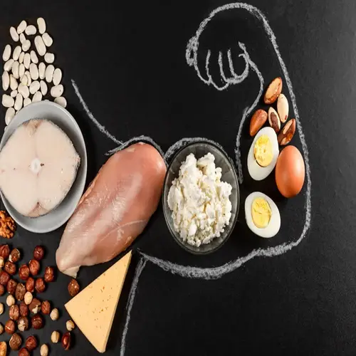 protein foods for fitness: fish, chicken, cottage cheese, eggs, cheese, nuts, and beans with chalk-drawn muscular arm