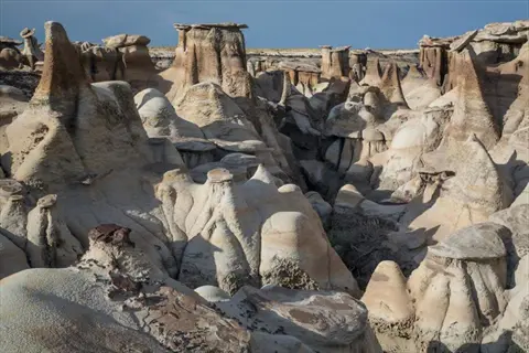 rock formation study of unique desert geology with towering hoodoos and eroded sandstone structures under a clear sky