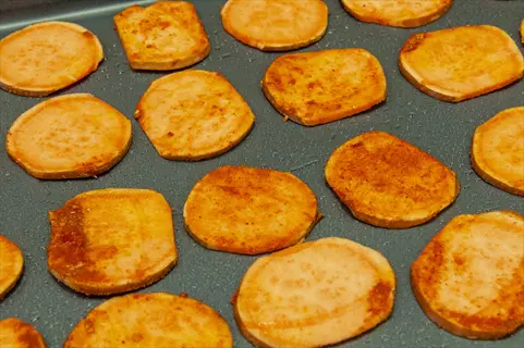 seasoned sweet potato slices (rich in vitamin a) arranged on a baking sheet