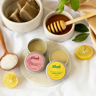 vilvah beauty products: lemon & honey lip balm, lip scrub, honey with dipper, soap, lemon balm honey - arranged with lemons and salt