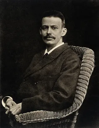 vintage portrait of niels finsen, danish physician and light therapy pioneer, seated formally in a wicker chair