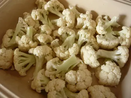white cauliflower florets arranged in a baking dish, fresh and ready for cooking