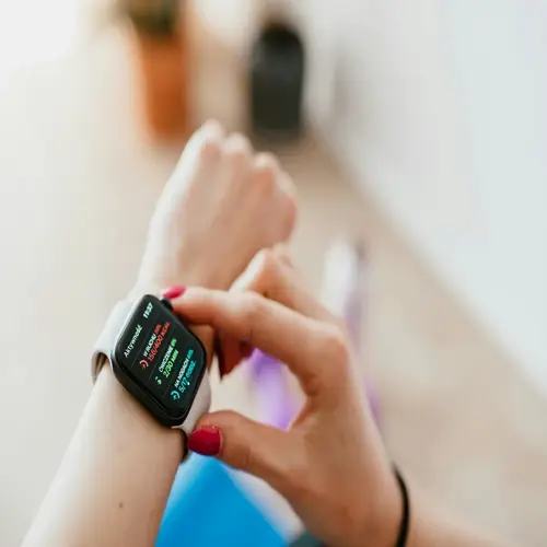 woman measuring heart rate with smartwatch on wrist, displaying health metrics on digital screen