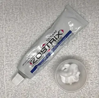 zostrix capsaicin cream tube and applied cream in small container for topical pain relief